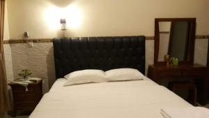 八丹拜Jepun Inn的一间卧室配有一张带黑色床头板和镜子的床