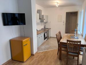 波茨坦Wohnung in direkter Innenstadtlage的厨房配有桌子,墙上配有电视