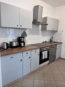 波茨坦Wohnung in direkter Innenstadtlage的厨房配有白色橱柜和炉灶烤箱。