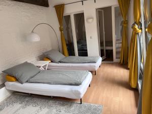 波茨坦Wohnung in direkter Innenstadtlage的配有黄色窗帘的客房内的两张床