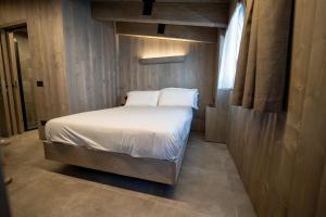 蓬泰迪莱尼奥Le Suites de San Campel RTA的一间小卧室,配有一张带白色床单的床和窗户