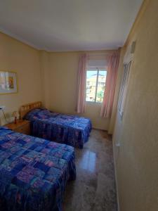 奥里韦拉Aguamarina, las Calitas, frente al mar的酒店客房设有两张床和窗户。