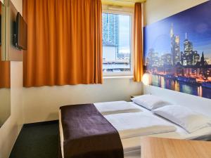 美因河畔法兰克福B&B HOTEL Frankfurt-Hbf的酒店客房设有床和窗户。