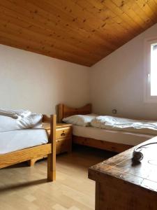 ChalaisChalet avec vue imprenable et au calme的一间卧室设有两张床和木制天花板