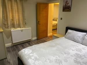 莱斯里普Ruislip Guest House的一间卧室设有床、窗户和门