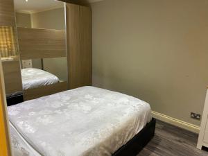 莱斯里普Ruislip Guest House的一间小卧室,配有一张床和镜子