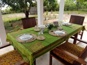 Villa Moringa Lodge的一张桌子,上面有绿桌布和盘子