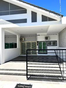 卢穆特Zh homestay teluk batik的前面有长凳的白色房子