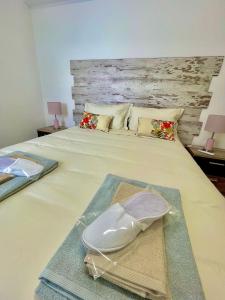 维拉维索萨APART Casas Brancas的一间卧室,配有一张带床头板和帽子的床