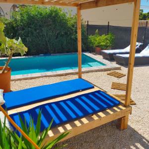 阿尔啼Casa Eline de Lujo Casco Antiguo Altea piscina privada y jardin的一张蓝色的床,位于游泳池旁