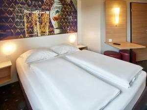 美因河畔法兰克福法兰克福北部酒店的一张大白色的床,位于酒店客房内