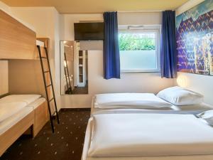 美因河畔法兰克福法兰克福北部酒店的一间卧室设有两张床,窗户配有蓝色窗帘