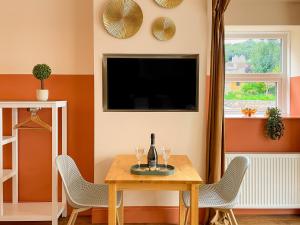 滨海韦斯顿Timbertop Suites - Adults Only的一间带桌子和电视的用餐室