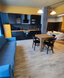 拉脱维亚索露丝俱乐部公寓的客厅以及带木桌和椅子的厨房。