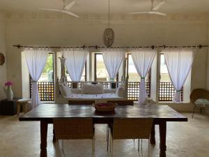 拉穆Swahili Dreams Apartments的一间带桌子和沙发的用餐室