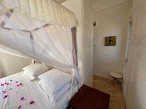 拉穆Swahili Dreams Apartments的一间卧室配有一张带天蓬的白色床
