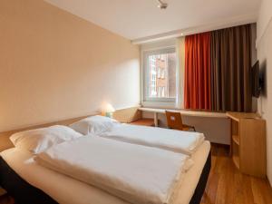 杜伊斯堡B&B Hotel Duisburg Hbf-Nord的酒店客房设有两张床和窗户。
