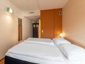 杜伊斯堡B&B Hotel Duisburg Hbf-Nord的卧室配有两张白色的床。