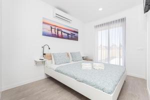 里斯本Príncipe Apartamentos e Suites的白色的卧室设有床和窗户