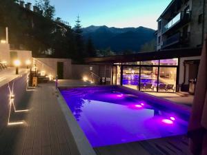 班斯科Private Spa Luxury apartments的一座建筑中一座带紫色灯光的游泳池
