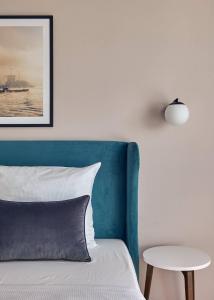 汉堡Makro Apartments的一张带蓝色床头板和一张桌子的床