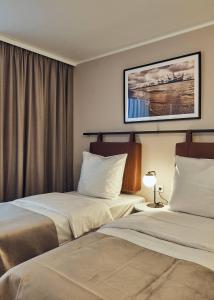 汉堡Makro Apartments的酒店客房设有两张床,墙上挂着一张照片。