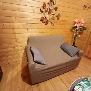 厄唐萨雷Chalet d'une chambre avec terrasse amenagee et wifi a L'Etang Sale的椅子和两张枕头坐在房间里