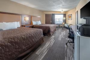 威利斯顿El Rancho Hotel的酒店客房设有两张床和电视。