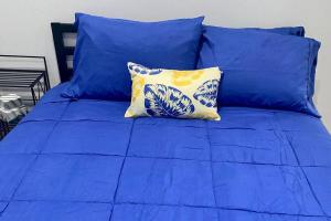 芝加哥Lincoln Park 3 BR Penthouse的蓝色的床,配有蓝色的床单和黄色的枕头