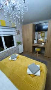 StevenstonSandylands Holiday Home的一间卧室配有一张带吊灯的大型黄色床