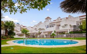 韦尔瓦Islantilla golf playa的大型公寓大楼前的游泳池