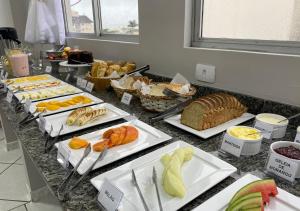弗洛里亚诺波利斯Ilha Forte Praia Hotel的自助餐,包括许多不同类型的面包和糕点