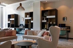 波尔多波尔多市中心希尔顿花园酒店的客厅配有沙发、椅子和桌子
