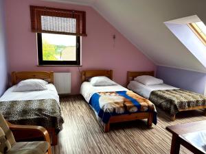 JeleniewoPokoje PRZY SZELMENCIE的阁楼卧室设有两张床和窗户。