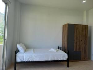 卡塔海滩L&P Guesthouse的一间卧室配有一张床和一个木制橱柜