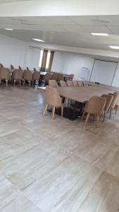 普里什蒂纳Hotel Konstantin的一间会议室,配有木桌和椅子