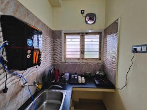 加赖古迪The Delux Cabin的一个带水槽和窗户的小厨房