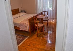 科米扎Marina Rooms的卧室配有一张床和一张桌子及椅子