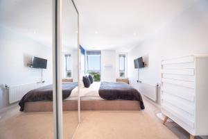 伦敦Top Floor Apt - 2 Bed/2 Bath + Private Balcony的一间卧室配有两张床和镜子