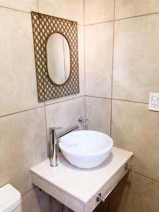 内乌肯Dptos amoblados NQN - Excelente ubicacion- ZONA CENTRO的浴室设有白色水槽和镜子