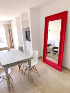 内乌肯Dptos amoblados NQN - Excelente ubicacion- ZONA CENTRO的客厅里设有一张红色镜子,配有桌椅