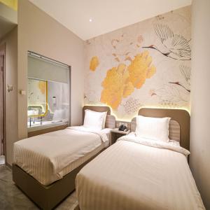 哥伦打洛省Yulia Hotel Managed by HIG的壁画客房内的两张床