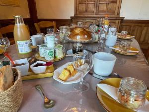 La Chapelle-du-BardLA MAISON D'EULALIE的餐桌上放有食物和酒杯的盘子