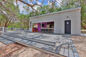 DriftwoodThe Driftwoods - Orange Tiny House的一个带白色建筑的大甲板,带紫色门