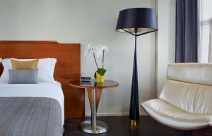 伦敦公园广场维多利亚酒店&度假村的一间卧室配有一张床、一把椅子和一盏灯