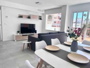 托雷德尔马尔Apartamento cerca de la playa, Torre Del Mar的客厅配有餐桌和电视