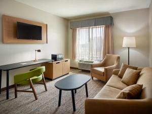 弗莱彻Fairfield Inn & Suites by Marriott Asheville Airport/Fletcher的酒店客房配有沙发、书桌和椅子