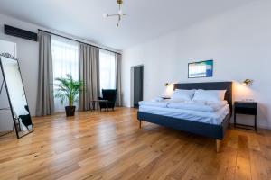 普热梅希尔Apartamenty Poniatowskiego的一间卧室配有一张床,铺有木地板