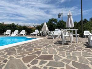 圣马西莫Cottage Ani & Mau - Villetta con piscina vicino gli impianti sciistici的一组桌椅和一个游泳池
