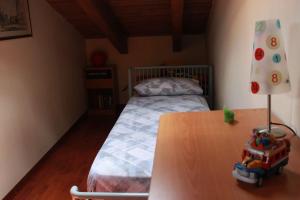 圣马西莫Cottage Ani & Mau的一间卧室配有一张床和一张桌子及玩具车
